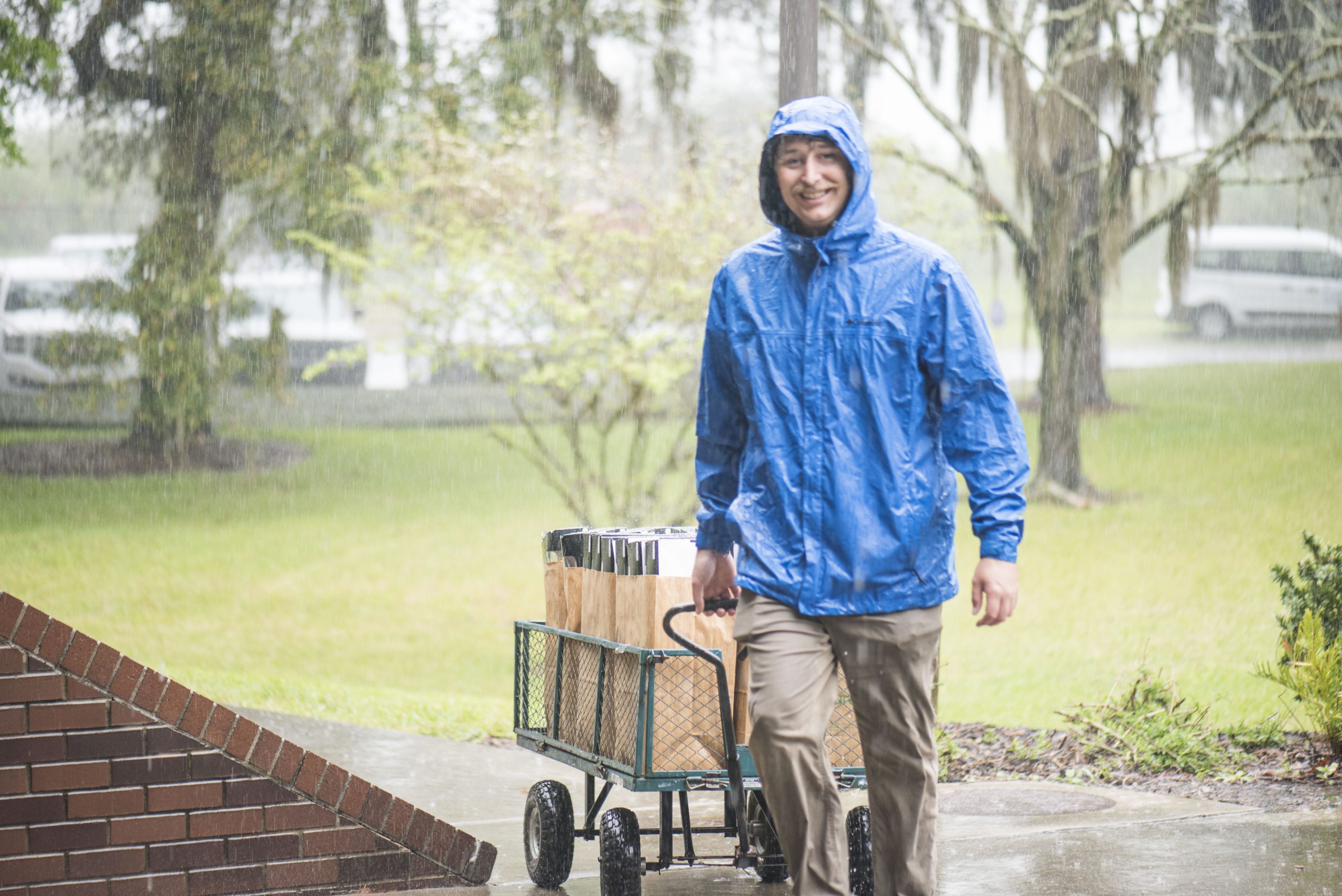 Figure 6. The UF/IFAS HBREL laboratory manager, Chris Oster, bringing in supplies in the rain. Photo credit: Bori Bennett